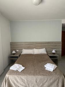 a bedroom with a large bed with two tables at Pensió Costa Brava in Sant Antoni de Calonge