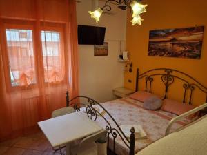 a bedroom with a bed and a tv and a window at Casa Vacanze Nantò 2 in Santa Maria di Castellabate +13 photos