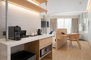a room with a kitchen and a living room at BTP Hotel Nakhon Phanom in Ban Noi Pho Kham