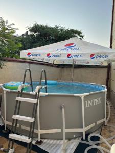 a swimming pool with two chairs and an umbrella at Apartment Registon in Samarkand