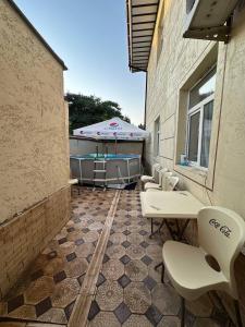 a patio with tables and chairs and an umbrella at Apartment Registon in Samarkand