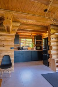 a kitchen with blue cabinets and a wooden ceiling at Bali domy RESORT & SPA in Laskowa