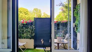 an open door to a patio with flowers on a fence at Studio port santa lucia in Saint-Raphaël