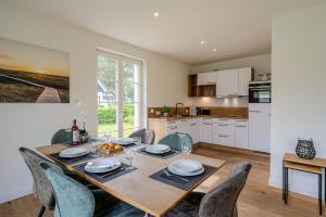 a kitchen and dining room with a table and chairs at Traumgarten Haus Leichte Brise in Prerow