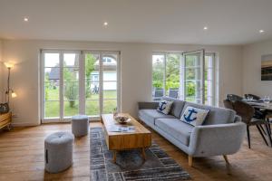 a living room with a couch and a table at Traumgarten Haus Leichte Brise in Prerow