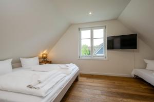 a attic bedroom with two beds and a window at Traumgarten Haus Leichte Brise in Prerow