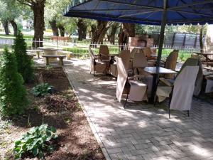 a patio with tables and chairs and an umbrella at Panoráma Szálláshely in Csongrád +7 photos