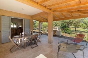 a patio with a table and chairs on it at Limbarto - Gîte climatisé au calme in Serra-di-Ferro