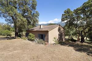 a small house in a field next to some trees at Limbarto - Gîte climatisé au calme in Serra-di-Ferro