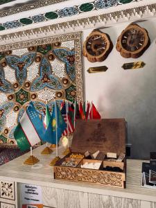 a display of flags and clocks on a wall at SILVER Inn in Bukhara