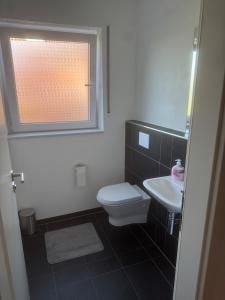 a bathroom with a toilet and a sink and a window at Lingen Stay 2 in Lingen +12 photos
