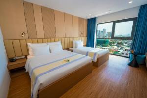 a hotel room with two beds and a large window at The Golden Crest Hotel Quy Nhon in Quy Nhon +53 photos