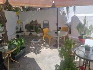 an outdoor patio with tables and chairs and plants at Marina's Rooms in Larnaca