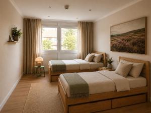 a bedroom with two beds and a window at Heidhof in Bispingen