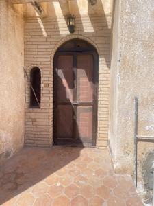 a large wooden door in a brick wall at chalet ramsis village in Alexandria