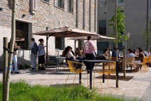 a group of people sitting at a table with an umbrella at Lemonade Stays Santiago de Compostela in Santiago de Compostela