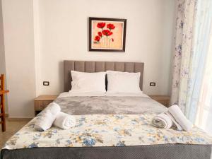 a bedroom with a bed with towels on it at The Rock Apartments in Himare