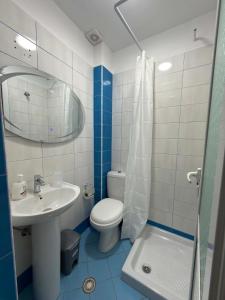 a bathroom with a sink and a toilet and a mirror at The Rock Apartments in Himare
