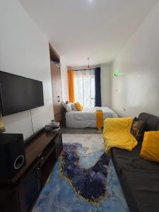 a living room with a couch and a flat screen tv at Tsavo in Kiambu