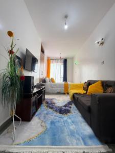 a living room with a couch and a tv at Tsavo in Kiambu