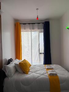 a bedroom with a large bed with a window at Tsavo in Kiambu