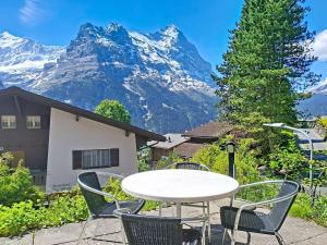 a table and chairs with a mountain in the background at Apartment Chalet Holzwurm-1 by Interhome in Grindelwald