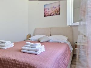 a bedroom with a pink bed with towels on it at Holiday Home Rudi by Interhome in Kraj