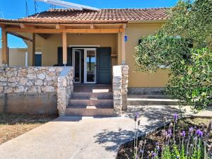 a small yellow house with a stone wall at Holiday Home Rudi by Interhome in Kraj