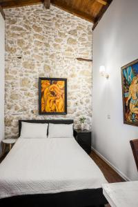 a bedroom with a white bed in a stone wall at Art House Near to Saint George Beach by Konnect in Págoi