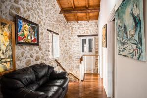 a living room with a leather couch in a room at Art House Near to Saint George Beach by Konnect in Págoi