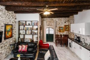 a living room with a couch and a ceiling fan at Art House Near to Saint George Beach by Konnect in Págoi