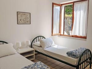 two twin beds in a room with a window at Apartment Villa Martinelli-1 by Interhome in Crone