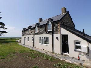 an old house with a black and white building at Rosemary Cottage 1 in Tywyn
