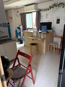 a kitchen with a red chair in a room at Yasuragi Nakasu in Fukuoka