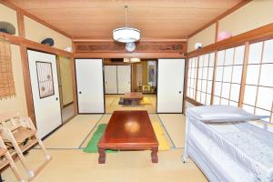 a room with a table and a bed and windows at Re-home in Izunokuni