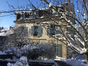 une maison dans la neige avec un arbre dans l'établissement Le Clocher, à Saint-Julien