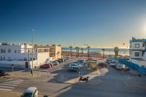 a parking lot with cars parked next to the beach at Caracolas Luxury House Duplex in Tarifa
