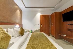 a bedroom with a large bed with a flat screen tv at Hotel Luxury Villa - Near IGI Airport Mahipalpur New Delhi in New Delhi