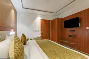 a bedroom with a bed with a flat screen tv at Hotel Luxury Villa - Near IGI Airport Mahipalpur New Delhi in New Delhi +21 photos
