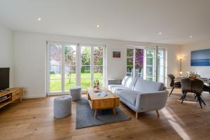 a living room with a couch and a table at Traumgarten Villa Harmonie in Prerow