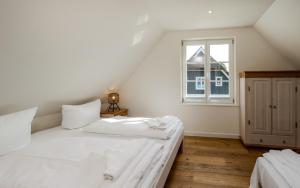a white bed in a room with a window at Traumgarten Villa Harmonie in Prerow