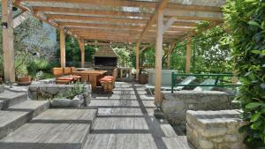 a wooden pergola with a table and a grill at Villa Skala by Villas Guide in Novi Vinodolski