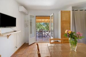 a living room with a table with a vase of flowers at Limbarto - Gîte climatisé au calme in Serra-di-Ferro
