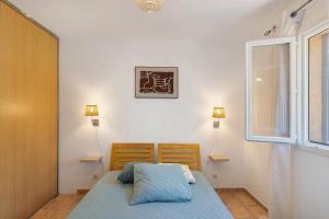 a bedroom with a bed and two chairs and a window at Limbarto - Gîte climatisé au calme in Serra-di-Ferro