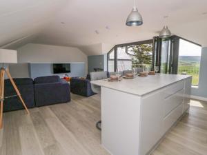 a kitchen and living room with a couch and a table at Rosemary Cottage 2 in Tywyn