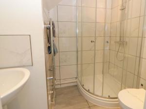 a bathroom with a shower and a toilet and a sink at Rosemary Cottage 2 in Tywyn +21 photos
