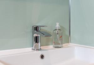 a bathroom sink with a soap bottle on a shelf at Summerside Cottage in Gullane +9 photos