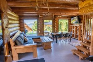 a log cabin living room with a couch and a table at Bali domy RESORT & SPA in Laskowa