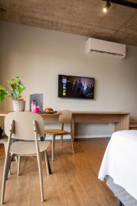 a room with a table and chairs and a tv on the wall at Studio Piedade 45 | More do seu jeito in Belém