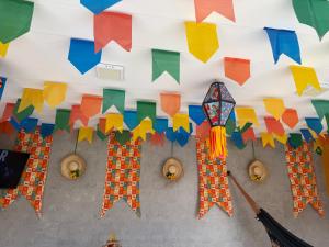 a room with colorful flags and kites hanging from the ceiling at A 3,3 km do Parque do Povo in Campina Grande